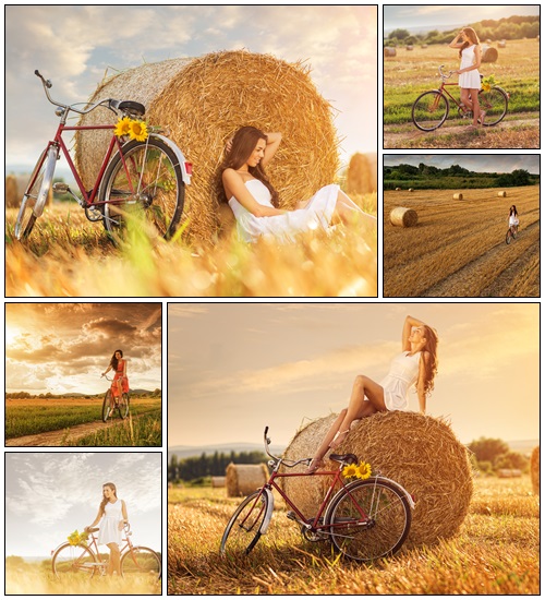 Beautiful woman cycling in a wheat field - Stock Photo